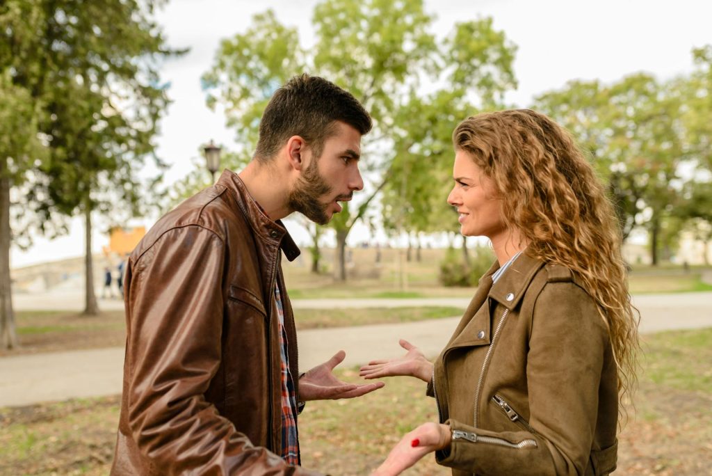 Man And Woman Wearing Brown Leather Jackets having an arguement
